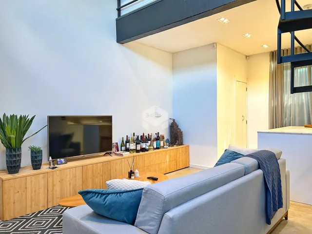 Sala de estar com sofá e televisão em um apartamento no Brasil.