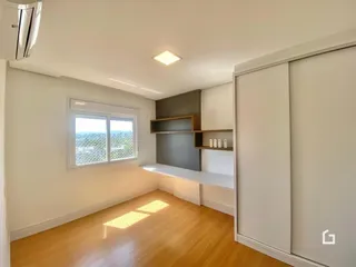 Sala de estar com piso de madeira clara e janela com vista.