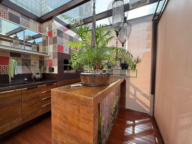 Interior de uma sala com piso de madeira e armários de cozinha.