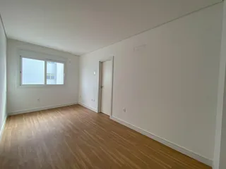 Sala de estar com piso de madeira clara e janela iluminada.