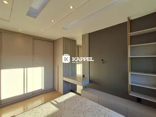 Interior moderno com piso de madeira e armários embutidos em um ambiente bem iluminado.