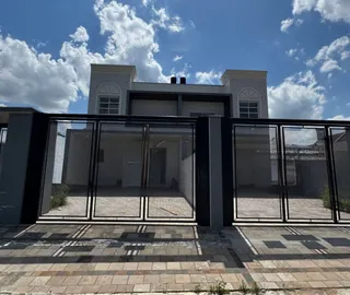 Fachada de uma residência moderna com grandes painéis de vidro.