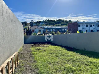 Vista externa da propriedade com muros e gramado na Lajeado.