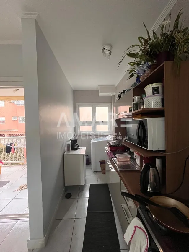 Corredor interno de uma residência com paredes brancas.