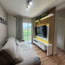 Sala de estar com sofá e televisão na parede.