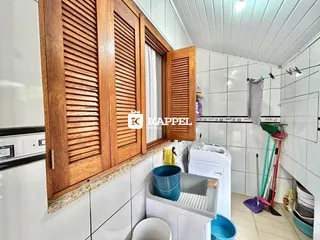 Cozinha com armários de madeira e revestimento branco nas paredes.