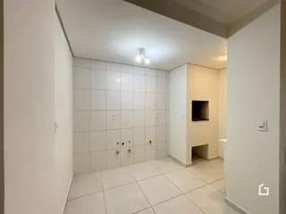 Foto de um corredor interno com paredes brancas e piso claro.