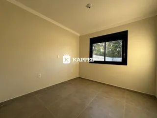 Foto interna de uma sala com paredes claras e piso de cerâmica.
