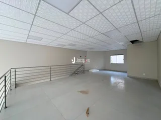 Vista interna de um espaço amplo e vazio com teto de grid.