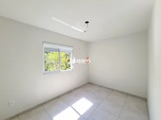Vista interna de um cômodo com piso de cerâmica e janela.