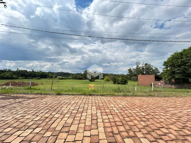 Vista externa de uma propriedade com campo gramado e cerca de arame.