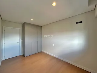 Ambiente interno de um imóvel com piso de madeira e armário embutido.