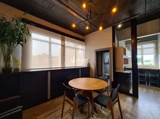 Interior de uma sala com piso de madeira e uma mesa de jantar.