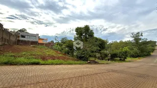 Vista externa de uma propriedade com terreno inclinado e vegetação ao fundo.