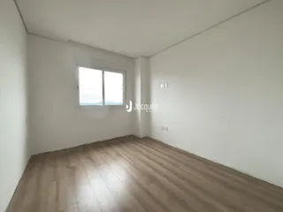 Sala de estar com piso de madeira e paredes brancas.