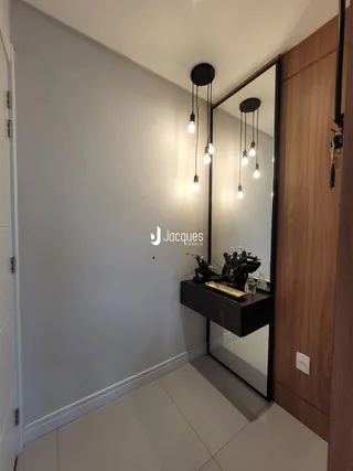 Hall de entrada com espelho e painel de madeira na residência.