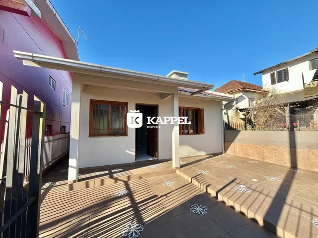 Vista externa da casa com um pátio coberto e piso de cerâmica.
