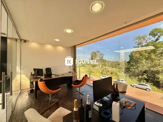 Uma sala de escritório com mesa de trabalho e vista para o exterior.