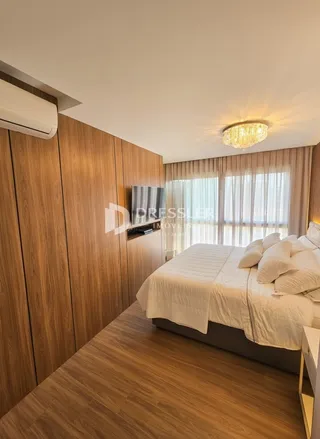Quarto com cabeceira e painéis de madeira em um imóvel no Brasil.