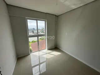 Ambiente interno com grande janela oferecendo vista para a paisagem urbana.