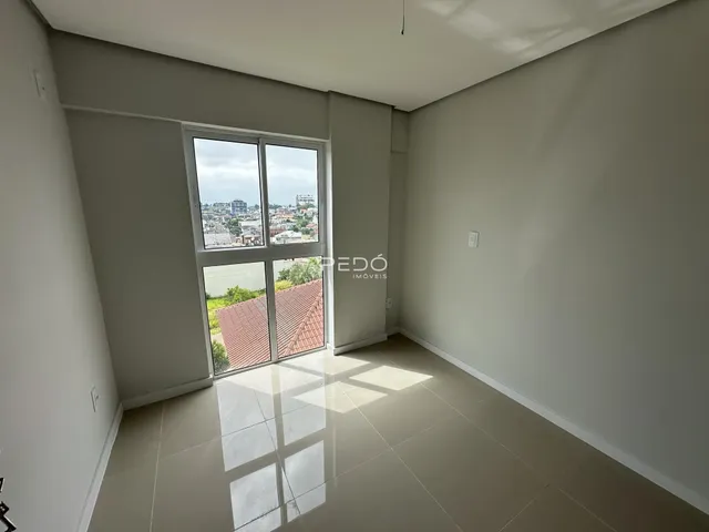 Ambiente interno com grande janela oferecendo vista para a paisagem urbana.