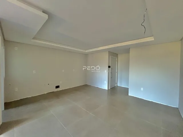 Imagem de uma sala de estar ampla e vazia em um imóvel.