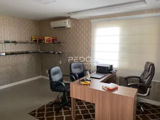 Foto de um escritório com mesas e estantes em um imóvel.
