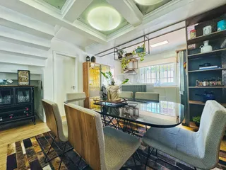 Sala de jantar com móveis modernos e piso de madeira clara.