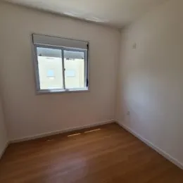 Foto de um cômodo interno com piso de madeira e uma janela.