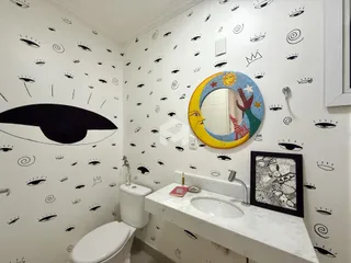 Foto de um banheiro com decoração de parede e bancada de mármore.