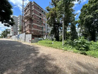 Vista externa de um prédio em construção em Lajeado, Brasil, com vegetação ao redor.