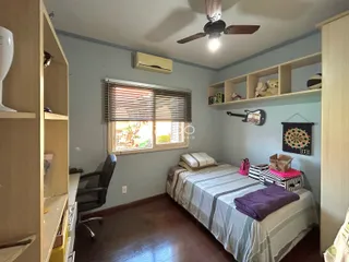 Quarto com piso de madeira e estantes em um apartamento em Lajeado.
