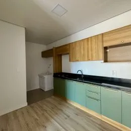 Esta é uma cozinha com armários de madeira e piso de madeira clara.