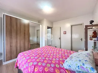 Quarto com cama e armário de madeira visível na imagem.