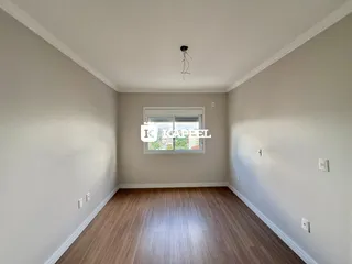Ambiente interno com piso de madeira e paredes claras em um imóvel.