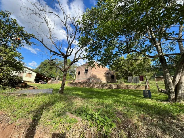 Fachada de uma construção antiga cercada por vegetação e grama.
