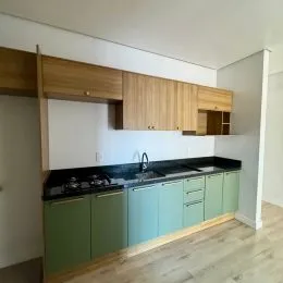 Foto de uma cozinha com armários de madeira e bancada escura.