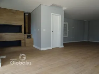 Imagem de uma sala de estar com piso de madeira e paredes cinzas.
