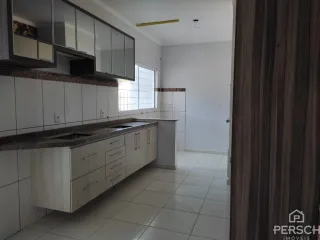 Uma cozinha com armários brancos e bancada clara é apresentada na propriedade.