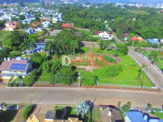 Vista aérea de uma área residencial em Lajeado, Brasil, mostrando casas e vegetação.