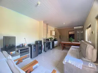 Sala de estar com cozinha integrada em imóvel no Lajeado, Brasil.