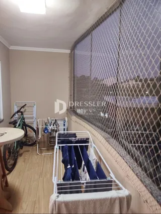 Vista interna de um ambiente com parede texturizada e grade de proteção.