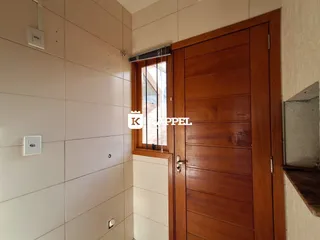 Parede interna com painel e porta de madeira em um ambiente residencial.