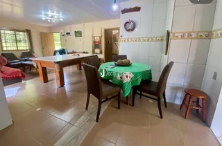 Sala de estar com mesa de madeira e cadeiras em um imóvel no Brasil.