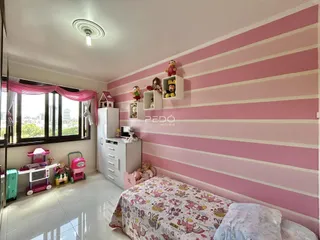 Quarto com paredes listradas rosa e branco e janela.