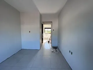 Corredor interno de uma residência com paredes brancas e piso de cerâmica.