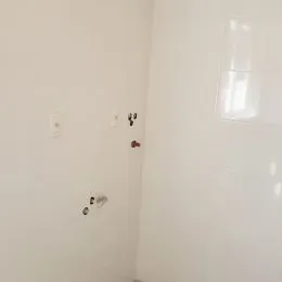 Foto de um corredor interno com paredes brancas.