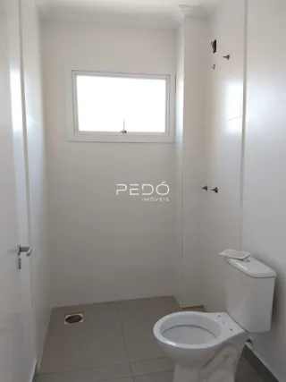 Foto de um banheiro interno com janela e vaso sanitário.