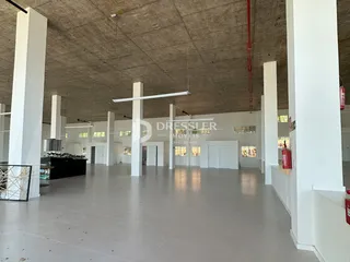Espaço interno amplo com pé direito alto e estrutura de concreto aparente.