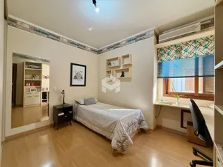 Quarto com piso de madeira e janela.